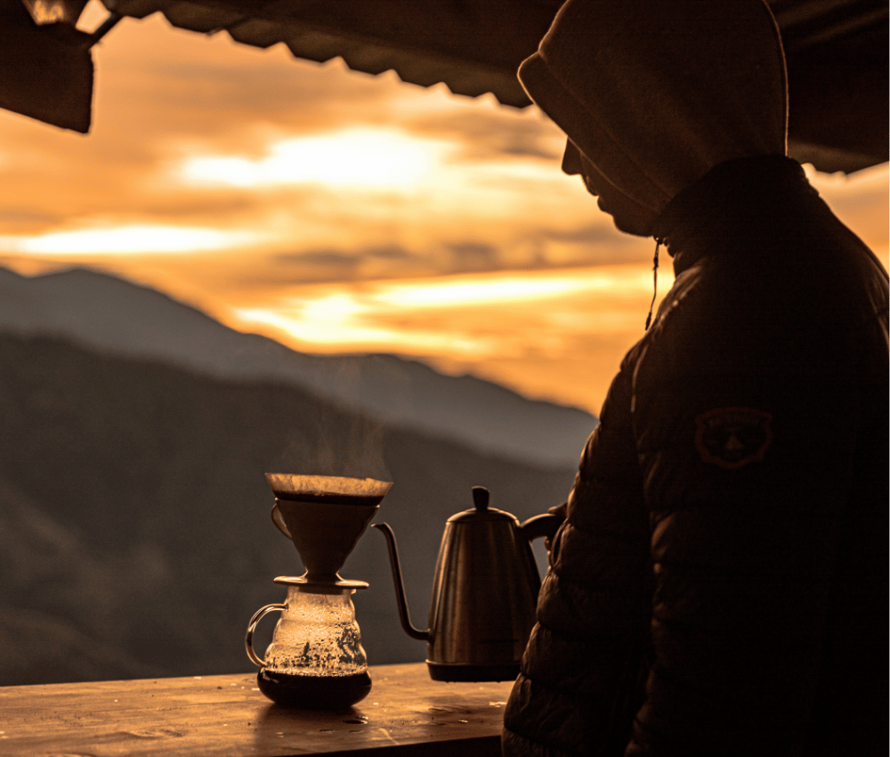 Kaffe bryggs utomhus under solnedgång utomhus vid en kaffeplantage