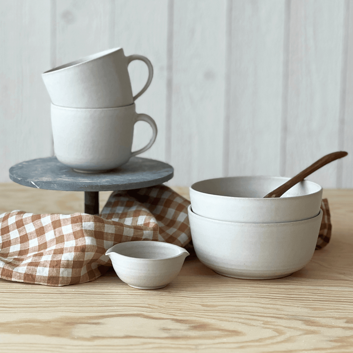 Vit handgjord keramik från frukostset Mini i servisen Lantliv med koppar, skålar och liten skål från Paradisverkstaden.