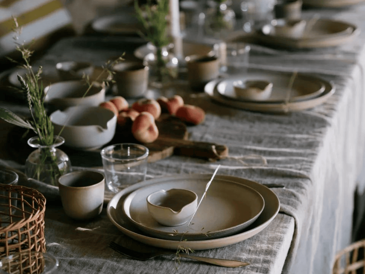 Sommardukning med keramik i en mjuk beige glasyr