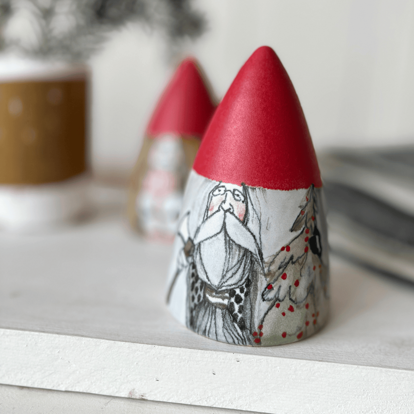 Tomte i keramik med julröd tomteluva. Paradisverkstaden Öland